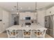 Well-lit kitchen showcasing a large island, white cabinetry, quartz countertops, and modern stainless steel appliances at 20420 Symphony Pl, Venice, FL 34293