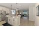 Open-concept kitchen with stainless steel appliances, a kitchen island, and sightlines to the living room at 20420 Symphony Pl, Venice, FL 34293