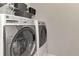 Modern laundry room with a front-load washer and dryer and storage above at 20420 Symphony Pl, Venice, FL 34293