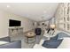 Open concept living room with a large TV and neutral decor featuring kitchen and dining areas at 20420 Symphony Pl, Venice, FL 34293