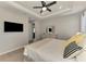 Bright main bedroom featuring a ceiling fan, TV, dresser with mirror, and neutral decor at 20420 Symphony Pl, Venice, FL 34293