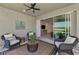 Inviting patio with wicker chairs, a table, and a view inside the home through sliding glass doors at 20420 Symphony Pl, Venice, FL 34293