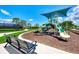 Community playground featuring a covered slide, bench seating and landscaped surroundings at 20420 Symphony Pl, Venice, FL 34293