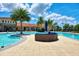 Resort-style pool features a unique island with lounge seating and swaying palm trees at 20420 Symphony Pl, Venice, FL 34293