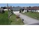 Aerial view of charming home with well-maintained lawn, two-car garage, and front yard at 2115 Pan American Blvd, North Port, FL 34287
