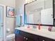 Bathroom featuring a dark vanity with a light countertop, a toilet and a door to the outside at 2115 Pan American Blvd, North Port, FL 34287