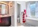 Well-lit bathroom with a soaking tub, toilet, vanity with a mirror, and modern gray decor at 2115 Pan American Blvd, North Port, FL 34287