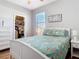 Cozy bedroom with a coastal themed bedspread, white furniture, and an organized closet at 2115 Pan American Blvd, North Port, FL 34287