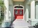 Inviting front entrance with a red double door and decorative stained-glass windows at 2115 Pan American Blvd, North Port, FL 34287