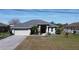 Charming one-story home featuring a two-car garage and manicured landscaping on a sunny day at 2115 Pan American Blvd, North Port, FL 34287
