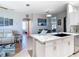 Bright and airy kitchen island with granite countertops, white cabinets, tile floor and open to living area at 2115 Pan American Blvd, North Port, FL 34287