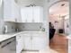 Well-equipped kitchen offers white cabinets, stainless steel dishwasher, tiled backsplash, and easy access to the living area at 2115 Pan American Blvd, North Port, FL 34287