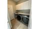 Functional laundry room features a sink, counter space, modern washer, and dryer with white cabinets at 2115 Pan American Blvd, North Port, FL 34287