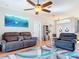 Inviting living room features a ceiling fan, comfortable seating, and stylish decor with an eye-catching blue wave painting at 2115 Pan American Blvd, North Port, FL 34287