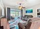 Cozy living room with modern furnishings, ceiling fan, and sliding glass doors to patio at 2115 Pan American Blvd, North Port, FL 34287