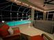 Tranquil screened-in lanai at night with a hot tub, and refreshing pool view at 2115 Pan American Blvd, North Port, FL 34287