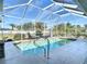 Beautiful screened-in pool with lounge chairs and a view of the clear blue sky and backyard landscaping at 2115 Pan American Blvd, North Port, FL 34287