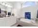 Bathroom features a soaking tub under a large arched window, double sinks, and ample counter space at 213 Venice Palms Blvd, Venice, FL 34292