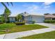 Beautiful home featuring manicured lawn, trimmed shrubs, tile roof and two-car garage with lovely curb appeal on a sunny day at 213 Venice Palms Blvd, Venice, FL 34292