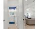 Hallway view showcases the transition to a stylishly appointed bathroom and cozy living space at 213 Venice Palms Blvd, Venice, FL 34292