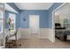Home office with blue accent wall and white desk bathed in bright natural light at 213 Venice Palms Blvd, Venice, FL 34292