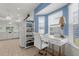 Home office with blue accent wall and white desk bathed in bright natural light at 213 Venice Palms Blvd, Venice, FL 34292
