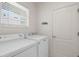 Well-equipped laundry room with modern washer and dryer, and ample natural light through a window at 213 Venice Palms Blvd, Venice, FL 34292