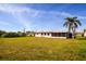 Expansive backyard featuring lush green space, a mature palm tree, and ample room for outdoor activities at 2221 Bal Harbour Dr, Venice, FL 34293