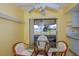 Cozy kitchen nook boasts a glass table, wicker chairs, and lovely views of the lake at 2221 Bal Harbour Dr, Venice, FL 34293