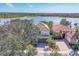 A home with a red tile roof sits next to a lake and other red-tiled homes in a community at 23138 Copperleaf Dr, Venice, FL 34293