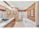 Bright bathroom featuring double vanity, garden tub and glass enclosed shower at 23138 Copperleaf Dr, Venice, FL 34293