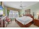 Primary bedroom with large windows, ceiling fan, and a queen bed at 23138 Copperleaf Dr, Venice, FL 34293