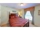 Well-lit bedroom featuring a four post carved wood headboard and a window with curtains at 23138 Copperleaf Dr, Venice, FL 34293