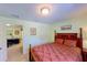 Well-lit bedroom featuring a carved wood headboard and doorway to a den at 23138 Copperleaf Dr, Venice, FL 34293