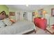 Well-lit bedroom with neutral carpet, light green walls, decorative lamps, and a red dresser at 23138 Copperleaf Dr, Venice, FL 34293