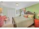 Well-lit bedroom has green walls, a wooden bed frame and double closet at 23138 Copperleaf Dr, Venice, FL 34293