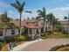 Exterior of the Sarasota National clubhouse, featuring a covered entry and palm trees at 23138 Copperleaf Dr, Venice, FL 34293