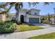 Two-story home featuring a well-maintained lawn, gray facade, tile roof, and attached two-car garage at 23138 Copperleaf Dr, Venice, FL 34293