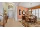 Inviting foyer with staircase, pendant lighting, peach accent wall, and dining table with seating at 23138 Copperleaf Dr, Venice, FL 34293