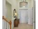 Bright foyer featuring a two story ceiling, entry door, and decorative mirror at 23138 Copperleaf Dr, Venice, FL 34293