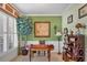 Bright office with a large front window, decorative tree, and hardwood desk and shelving at 23138 Copperleaf Dr, Venice, FL 34293