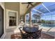 Screened in lanai featuring a dining table, stainless grill and stunning views of a private pool and lake at 23138 Copperleaf Dr, Venice, FL 34293
