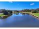 Scenic pond view with mature trees, shrubs, and lush green grass at 23138 Copperleaf Dr, Venice, FL 34293