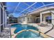 Inviting screened-in pool and hot tub with an expansive patio for outdoor living at 23138 Copperleaf Dr, Venice, FL 34293