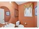 Quaint powder room with patterned wallpaper, oval mirror and window with decorative valance at 23138 Copperleaf Dr, Venice, FL 34293
