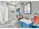 Bright bathroom featuring a blue vanity, white sink, and wood-look accent wall at 2371 Scenic Dr, Venice, FL 34293