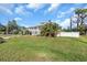 Beautiful two-story house with a metal roof and wrap-around balcony surrounded by lush greenery at 2371 Scenic Dr, Venice, FL 34293