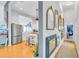 Hallway with wood floors and a gallery wall of various mirrors, leading to a kitchen at 2371 Scenic Dr, Venice, FL 34293