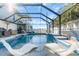 Relaxing screened pool with a spillover spa and comfortable lounge chairs for outdoor enjoyment at 2371 Scenic Dr, Venice, FL 34293