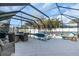 Enclosed screened in pool and patio area with outdoor furniture and tiled decking at 2371 Scenic Dr, Venice, FL 34293